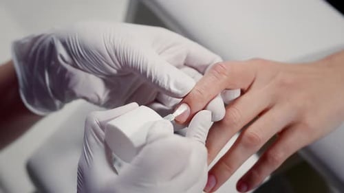 Manicurist Applying Clear Nail Polish to Client