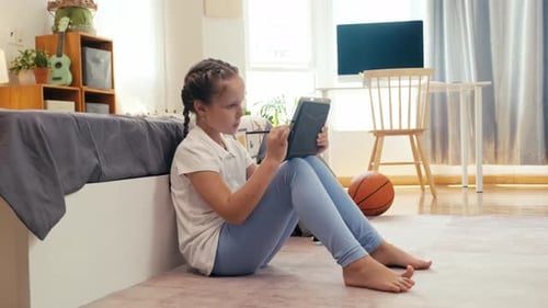 Child Uses Tablet with Stylus at Home