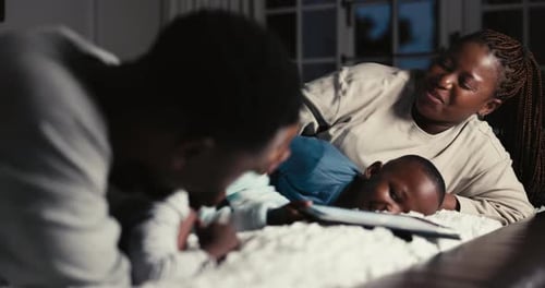 Happy Family Using Tablet Together at Night