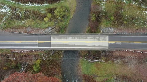 Over the bridge and creek view with snow on ground in winter