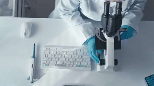 Scientist working in a lab looking through microscope