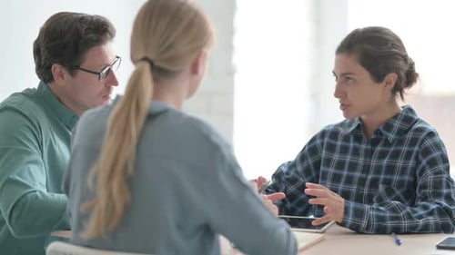 Business Meeting with Three People at a Table