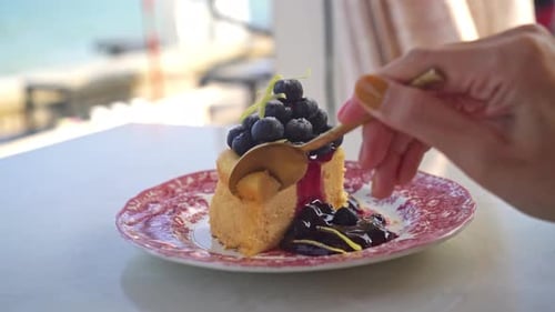 Small Cake Topped with Blueberries Being Eaten