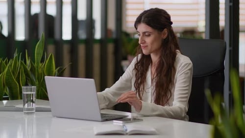 Woman Cheering at Desk in Office After Typing