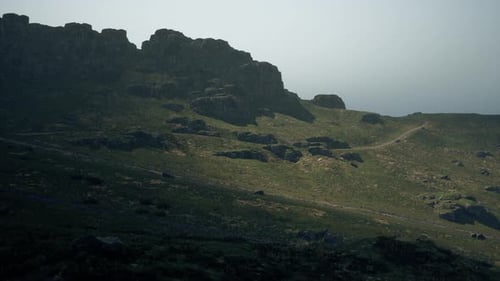 A Grassy Hill with Rocks and Grass on the Side