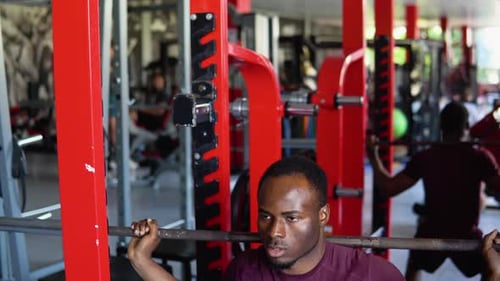 Black Bodybuilder Doing Squatting with a Barbell on Shoulder African Man Lifting Weight in Gym
