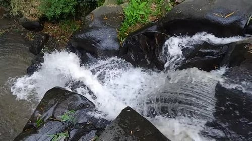 das rauschende Flusswasser fließt durch die schwarzen Felsen. Frisches Konzept der Natur zum Entspannen im Klang