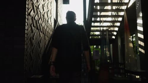 Adult Man Climbs the Stairs of a Wooden Building
