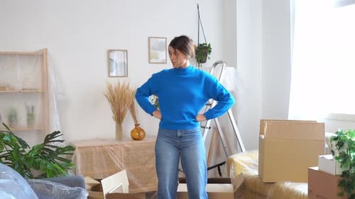 Young Woman Unpacking Boxes in New Apartment