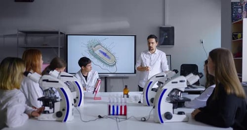 Teacher And School Students In Classroom Pupils Studying Biology Tutor Explaining Cell Structure