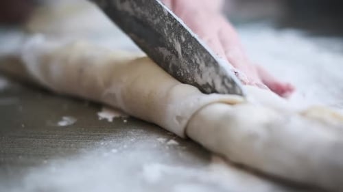Cutting Dough Roll with Chocolate Filling Into Pieces