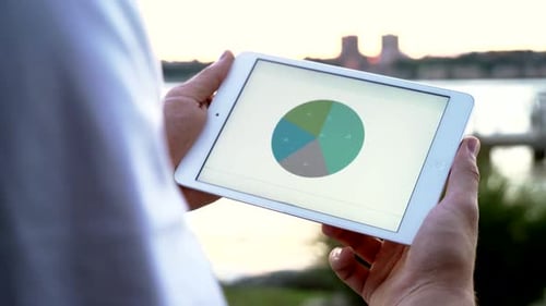 Personne utilisant un écran de tablette numérique comptabilisant les bénéfices de l'entreprise, tableaux de données