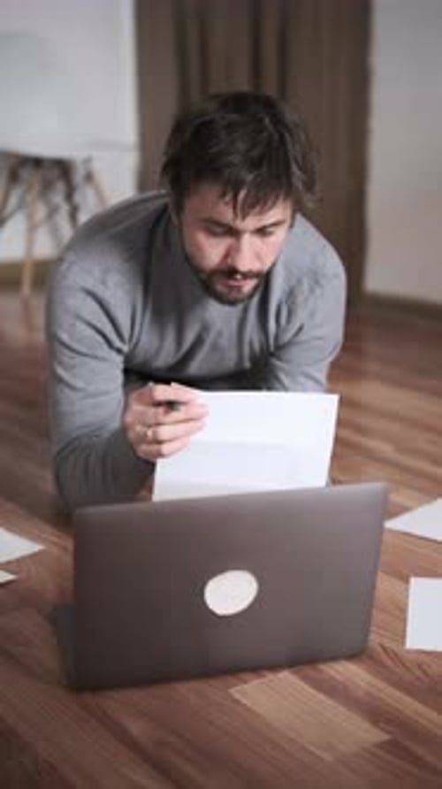 Man Paying Bills Online at Home Using Laptop and Documents Financial Management Remote Payment