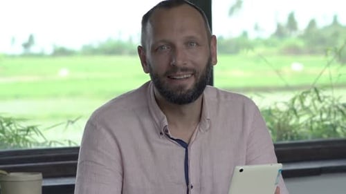 Man Using Tablet Device Indoors by the Window