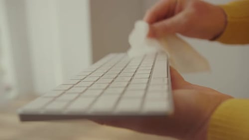 Coronavirus Cleaning COVID19 Quarantine Closeup Office Cleaner Disinfecting a Wireless Keypad with