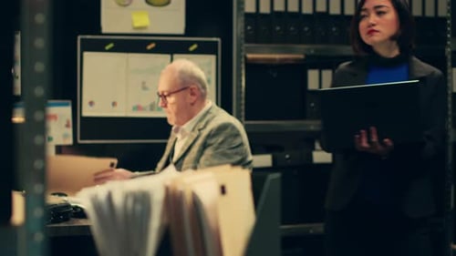 Woman Working on Laptop with Man at Desk