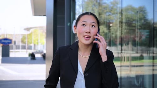 Woman Talking on Phone Outside Office Building