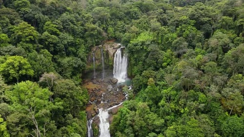 Aerial View of Powerful Waterfall in Lush Green Jungle