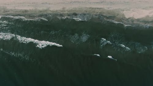Aerial View of Waves Crashing on Beach