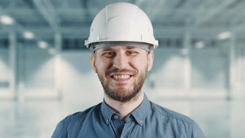 A Builder is Looking to Camera and Smiling Happily at Building Site