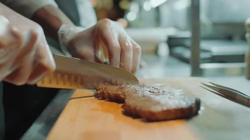 Chef Slicing Cooked Meat in Commercial Kitchen