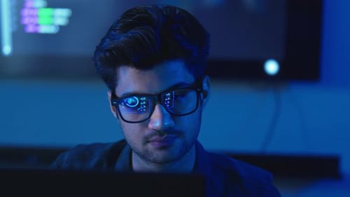 Männlicher Programmierer vor der Kamera mit Code und Interface
