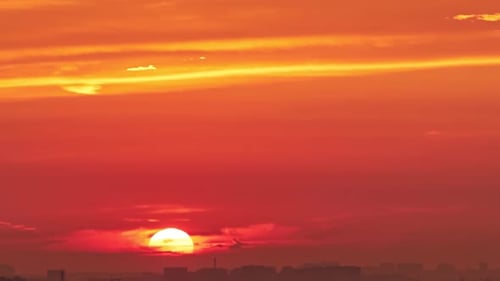 A big red sun in the dawn sky, a hot summer landscape. Morning sky in bright sunlight