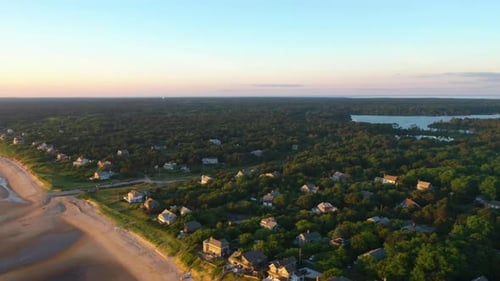 Cape Cod Bay Aerial Drone Footage of Beach Front Houses, Trees and Marsh at Low Tide During Golden H