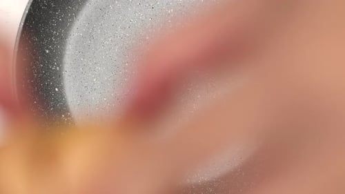 femme craquant un œuf dans une poêle, chute de jaune d'oeuf et d'albumen, forme imparfaite.