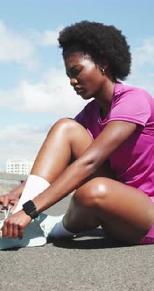 Athlete, black woman and tie shoes with smart watch for getting ready, fitness and exercise on road