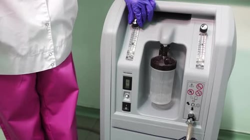 Gloved Hand Adjusting Oxygen Flow in Hospital