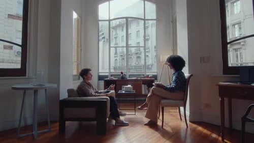 People Talking in an Office with Large Windows