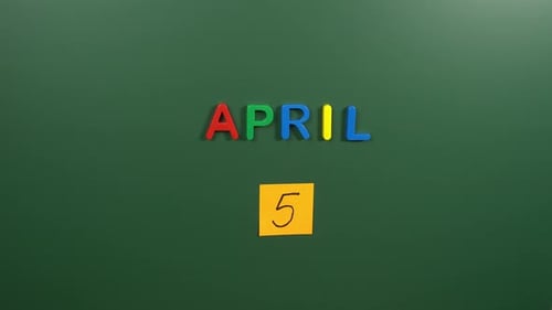 Hand sticking a sticker 5 April calendar day on school board. 5 date of April. Fifth day April