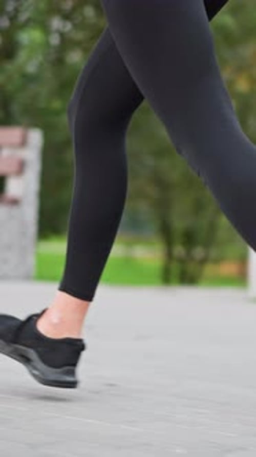 Closeup View of Woman's Legs Running in Park Path with Fitness Sneakers and Leggings