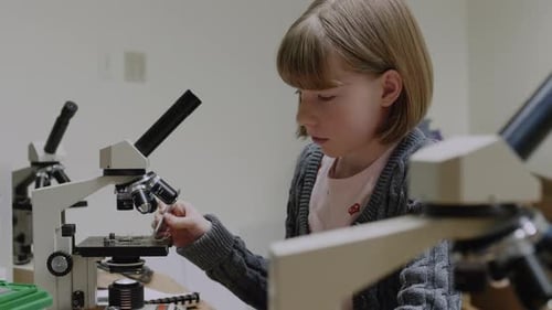 Girl Using Microscope in Scientific Lab Experiment