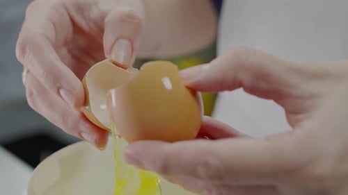 Close Up of Hands Cracking an Egg
