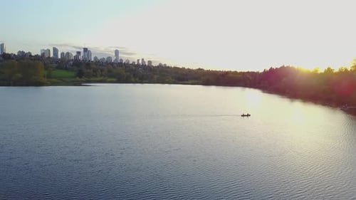 Aerial Footage of a Lake in the City Park During a Colorful and Vibrant Sunset with Red Color Sky
