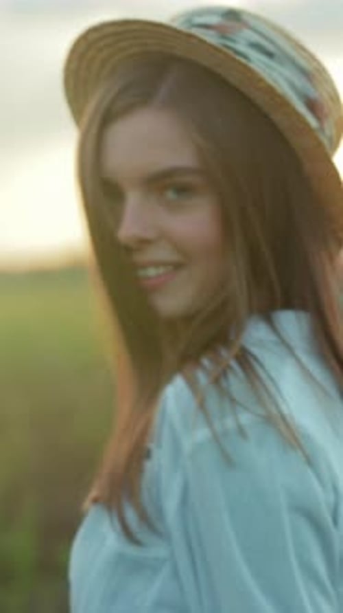 Portrait chaud et ensoleillé Image vivante d'une femme souriante avec un chapeau de paille et un soleil radieux qui l'illumine
