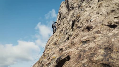 Man Athlette Climbing on the High Rock