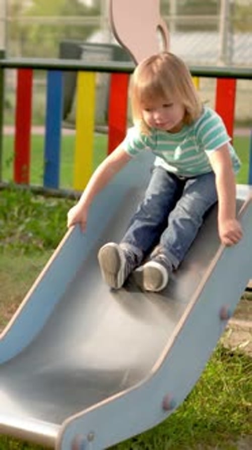 Child Having Fun on Playground Slide