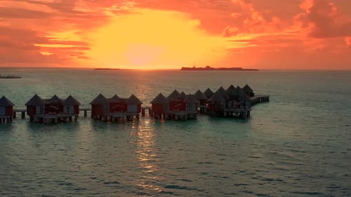 Overwater Villas at the Time Amazing Sunset in Tropical Sea with Coral Reef
