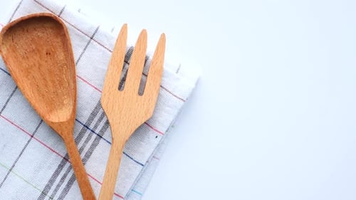 Wooden Cutlery Fork and Spoon on a Chopping Board on Table