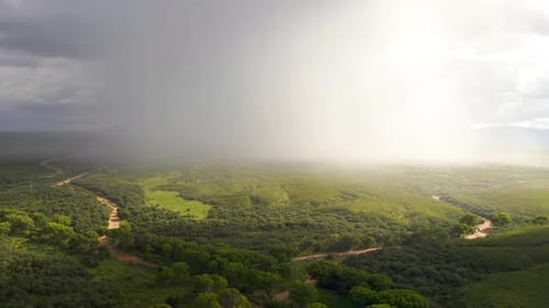 Dramática tormenta monzónica sobre pastizales en Arizona con una curva de río.
