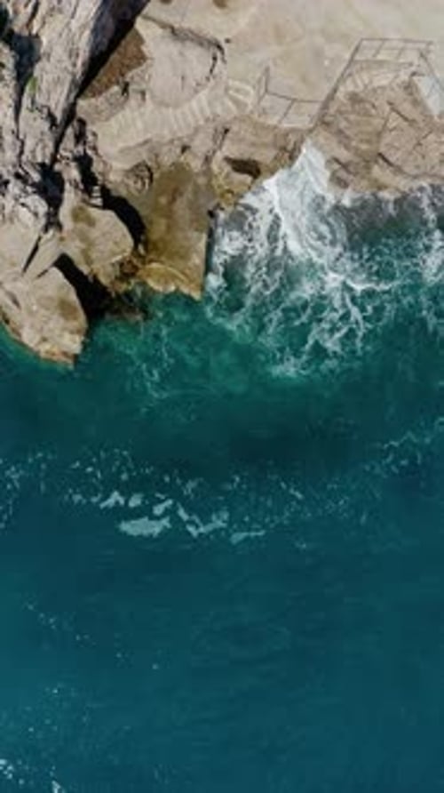 Vertical Top Down Aerial View Highlighting Coast Erosion caused by constant sea wave impact. Drone