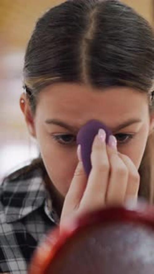 Teenage Latina Carefully Applying Cosmetics in Studio Lighting Young Latina Performing Her Makeup