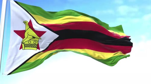 Waving Flag of Zimbabwe Against Blue Sky