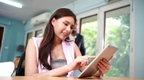 Vidéo d'une femme asiatique utilisant une tablette et travaillant au bureau