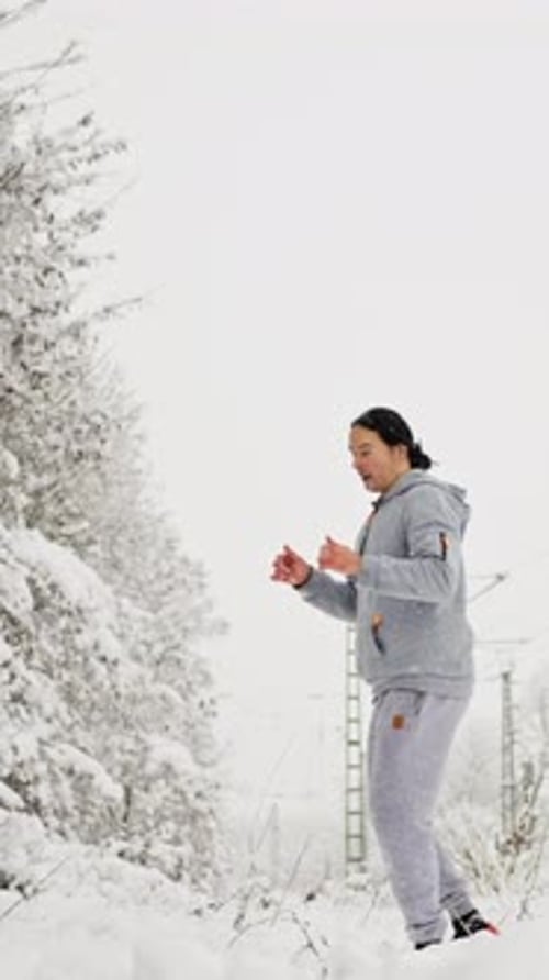 Man Exercises With Kicks Outdoors in a Snowy Forest
