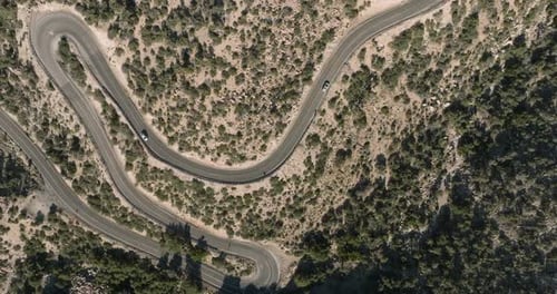 a road with cars driving through the desert
