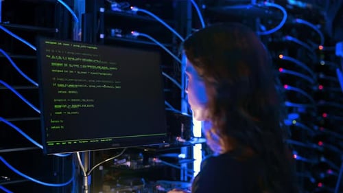 Frau programmiert in einem Serverraum